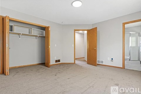 A spacious room with a large closet and a mirror on the wall.