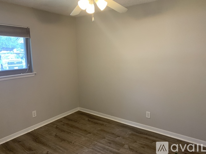 A room with a window and a fan on the ceiling.