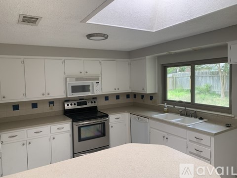 A kitchen with white cabinets and appliances is available for rent.