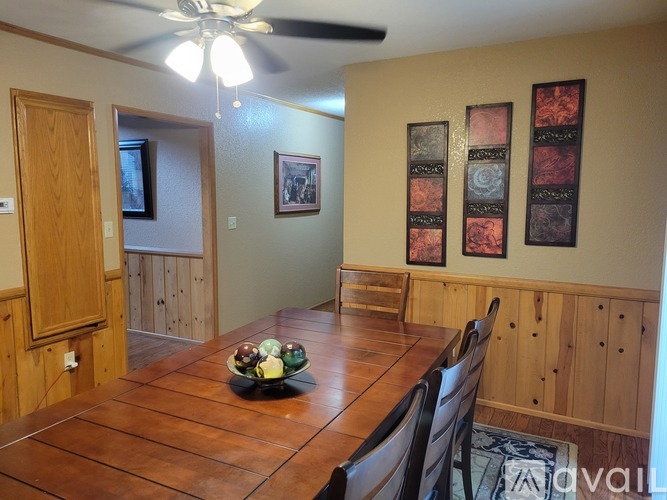 A dining room with a wooden table and chairs.