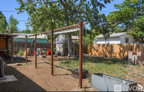 A backyard with a swing set and a fence.
