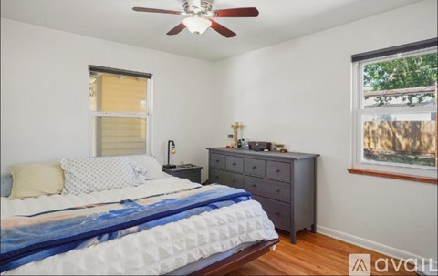 A bedroom with a bed, dresser, and window.