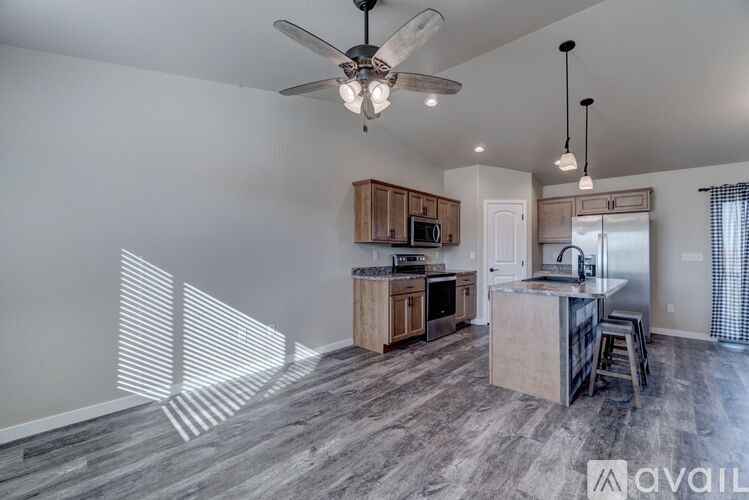 A modern kitchen with wooden cabinets and a ceiling fan.