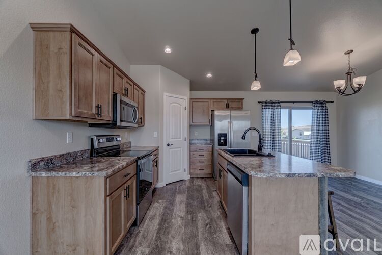 A kitchen with wooden cabinets and granite countertops.
