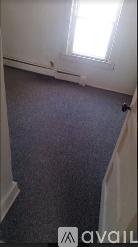 A room with a carpeted floor and a window.