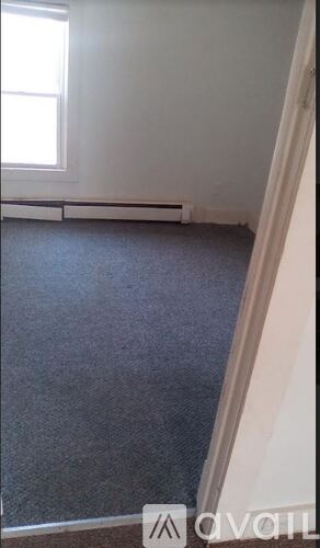 A room with a carpeted floor and a window.