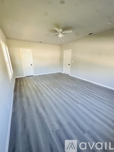 A room with a carpeted floor and two doors.