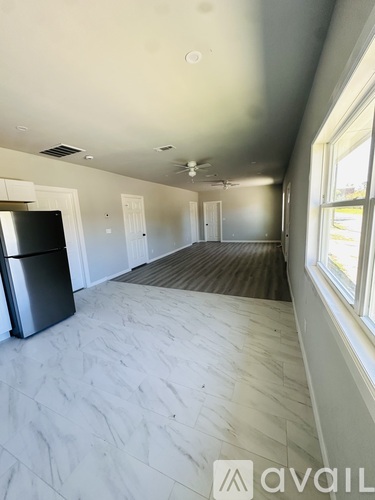 A kitchen area with a fridge and a window.