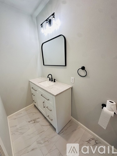 A bathroom with a white vanity and marble countertop.