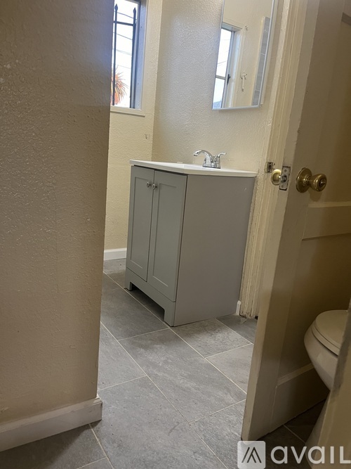A bathroom with a grey cabinet and a toilet.