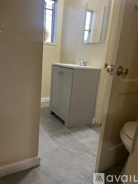 A bathroom with a grey cabinet and a toilet.