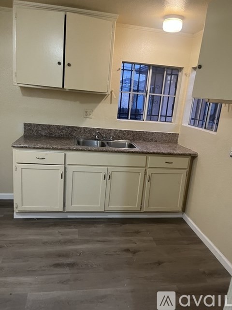A kitchen with white cabinets and a granite countertop.
