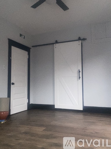 A room with a white door and a brown carpet.
