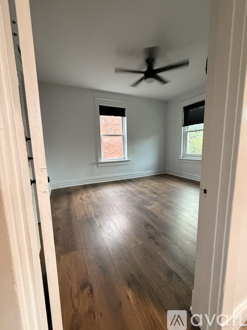 A room with wooden floors and a ceiling fan.