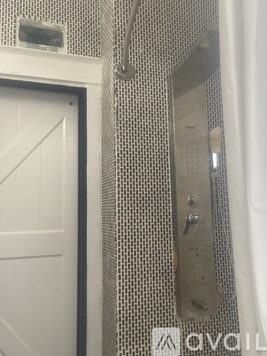 A white door is next to a wall with a control panel.