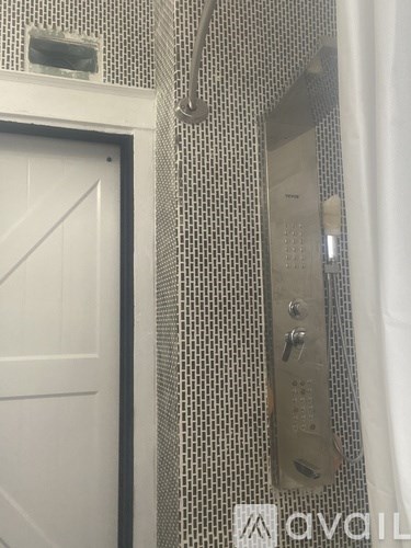 A white door is next to a wall with a control panel.