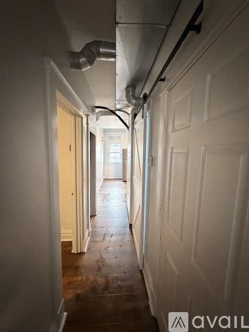 A long hallway with doors on both sides and a light at the end.