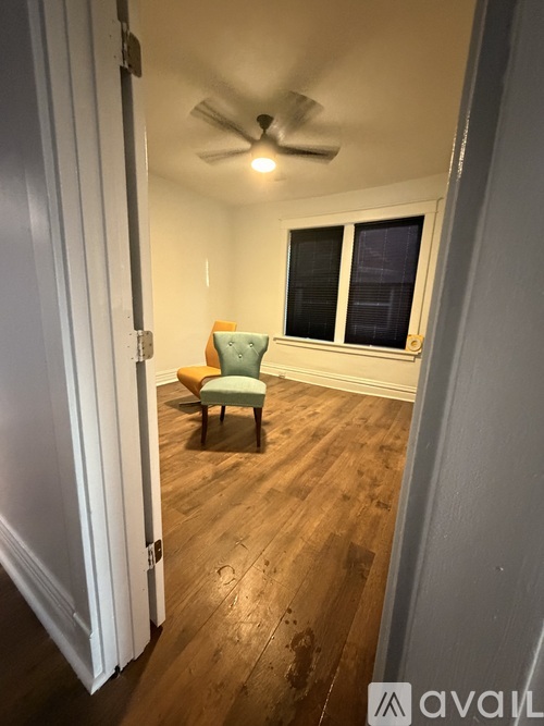 A room with a wooden floor and a ceiling fan.