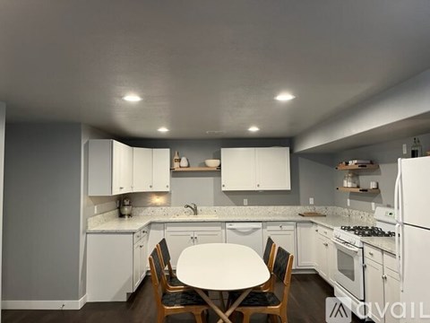 A kitchen with white appliances and cabinets.