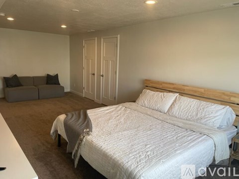 A bedroom with a large bed and a couch.