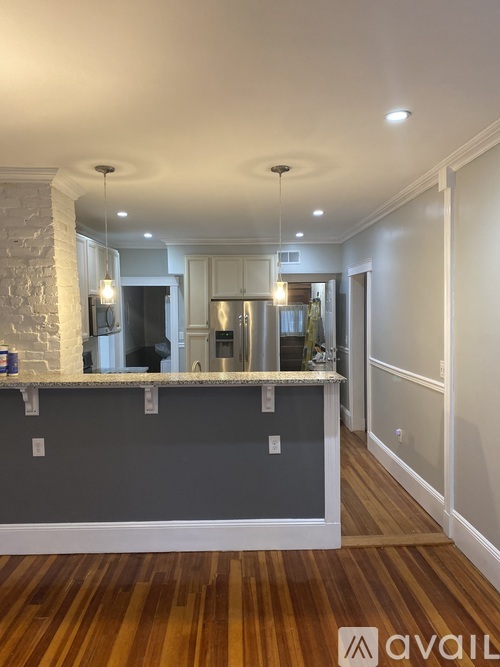 A kitchen with a wooden floor and a stone pillar.