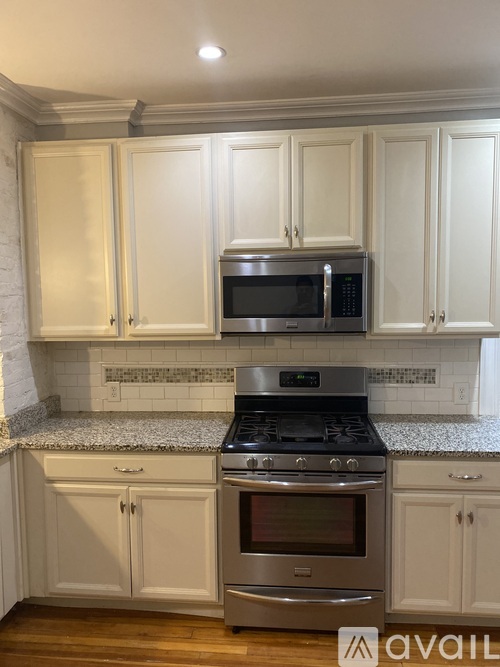 A kitchen with white cabinets and a stainless steel oven.