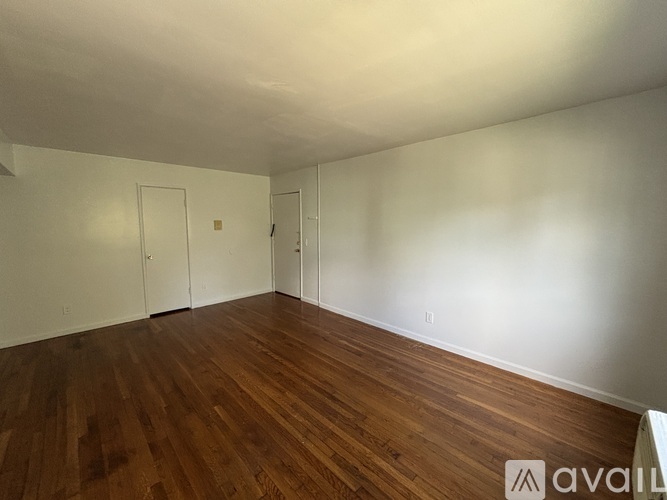 Empty room with wooden floors and white walls.
