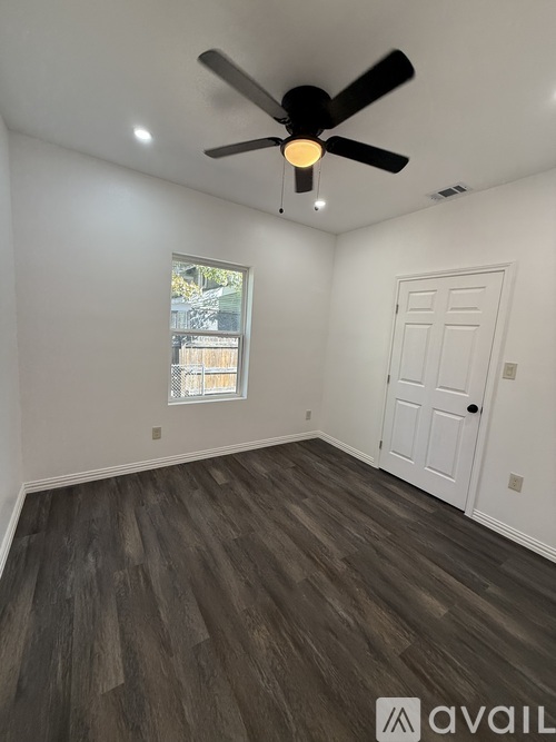A room with a ceiling fan and a door.