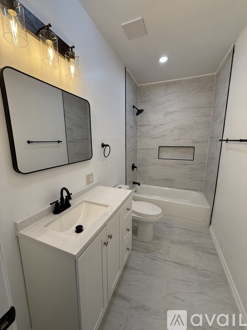 A bathroom with a sink, toilet, and shower.