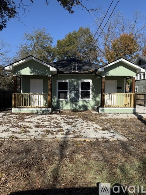 A two-story house with a porch and a front yard.