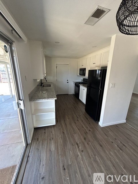 A kitchen with black appliances and white cabinets.