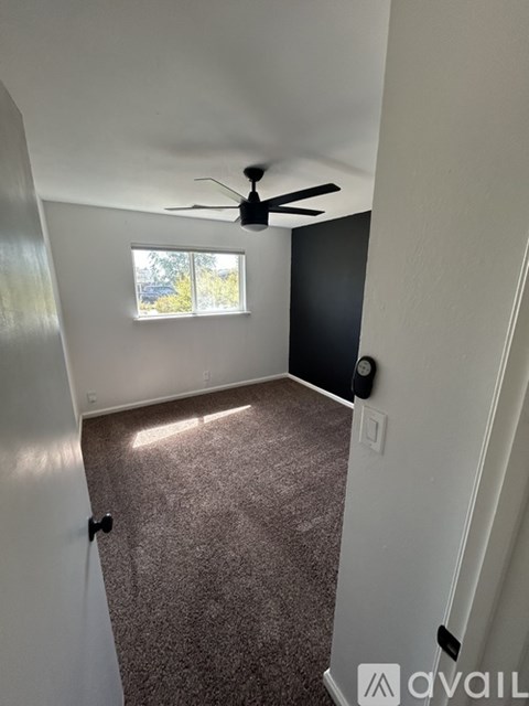 A room with a ceiling fan and a window.