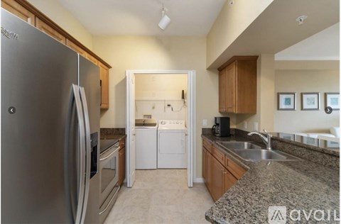 A kitchen with a stainless steel refrigerator and a granite countertop.