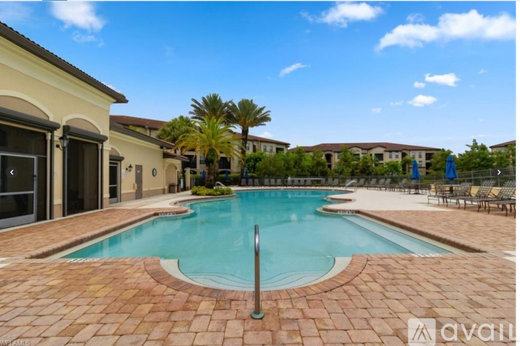 A large outdoor swimming pool surrounded by a brick patio.