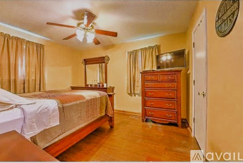 A bedroom with a bed, dresser, and mirror.