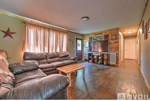 A living room with a leather sofa and a wooden coffee table.