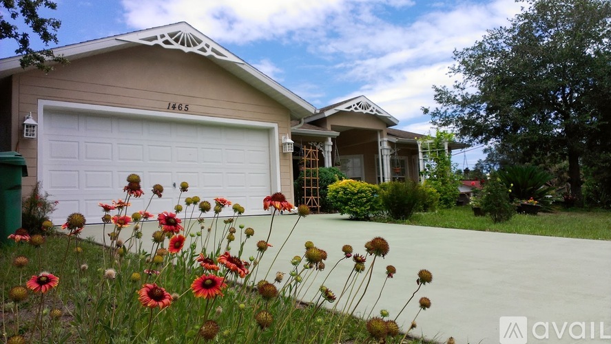 A house with a white garage door and a number 1465 on it.