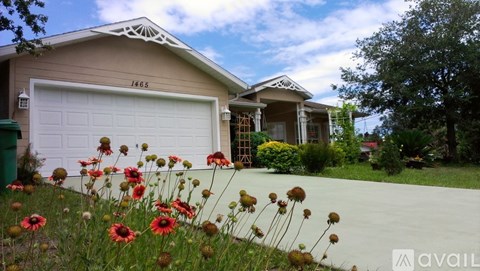 A house with a white garage door and a number 1465 on it.