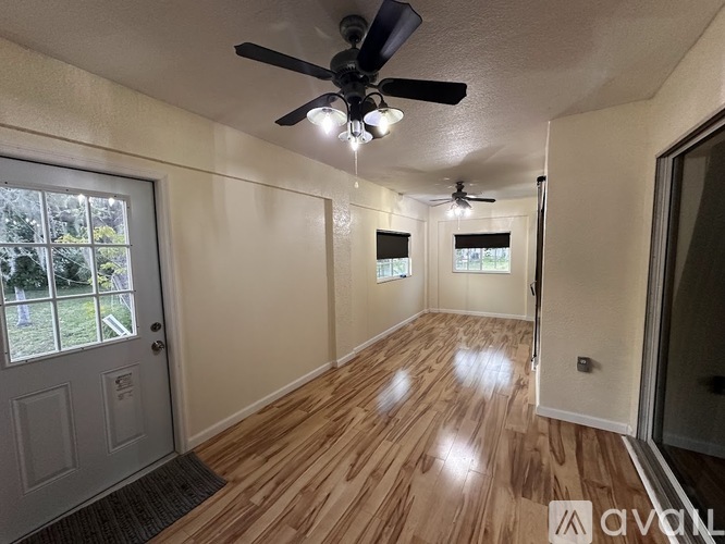A room with wooden flooring and a ceiling fan.