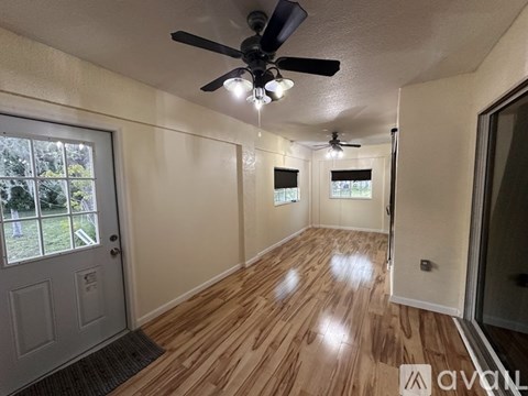 A room with wooden flooring and a ceiling fan.
