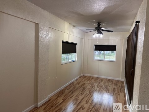 A room with wooden flooring and a ceiling fan.