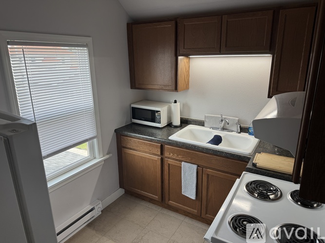 A kitchen with brown cabinets and a white sink.