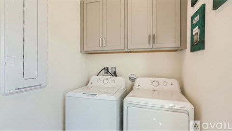 Two white front loading washing machines in a laundry room.