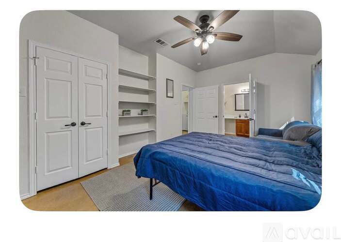 A bedroom with a bed, a ceiling fan, and a closet.