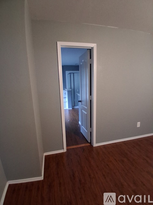 A room with a wooden floor and a white door.