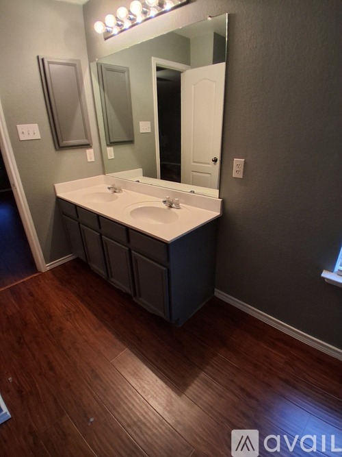 A bathroom with a white sink and a mirror.