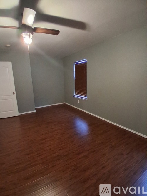 A room with wooden floors and a ceiling fan.