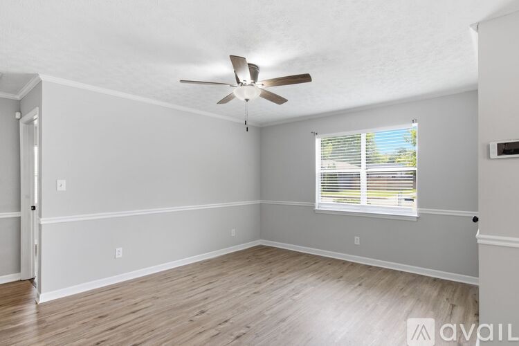 A room with a ceiling fan and a window with blinds.