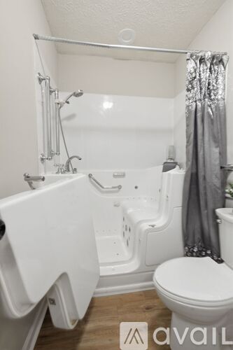A white toilet sits next to a white bathtub in a bathroom.