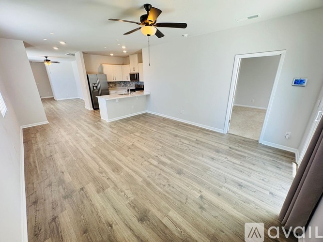 A spacious room with a ceiling fan and lighting fixtures.